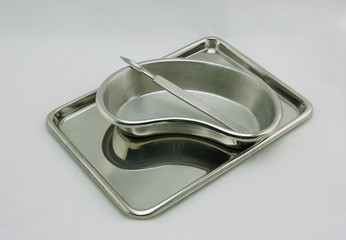 Scalpel in emesis basin on medical tray