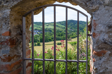 Fototapeta premium country views through Iron grating medieval window