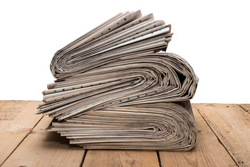 Pile of newspapers on a wooden table