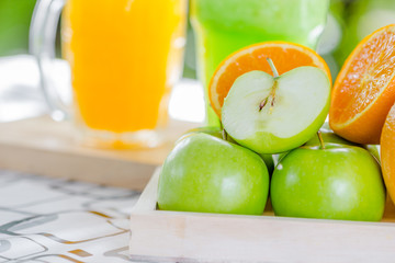 fresh orange and fresh green apple on woodle