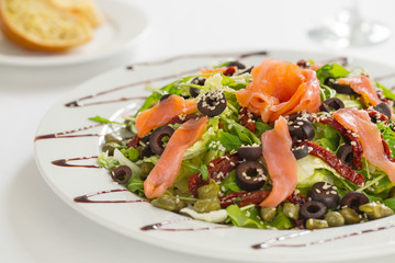 Salmon salad with dried tomatoes, olives and sesame seed