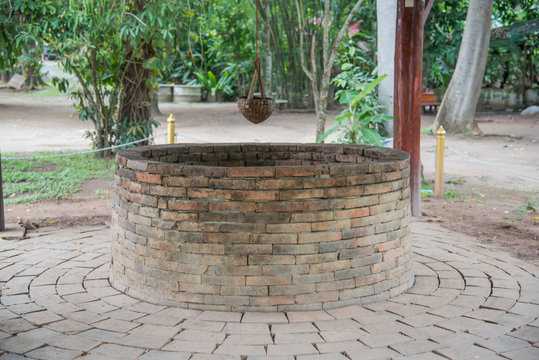 Ancient brick well and Bamboo Basket for dip up water