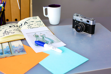 Designers table with camera and tools, cup