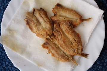 Pescado frito en plato con servilleta