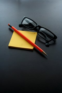 Notepad, pencil and eyeglasses