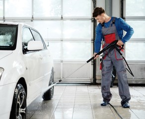 Fototapeta na wymiar Man worker washing car on a car wash