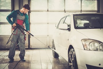 Man worker washing car on a car wash