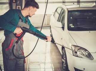 Man worker washing car on a car wash