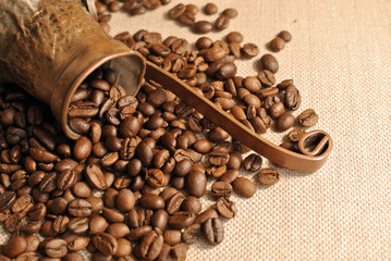 Coffee beans and vintage copper turkish coffee pot (cezve or ibrik) on the cloth sack