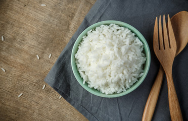 Bowl of Organic White Rice with wooden spoon & fork - soft focus