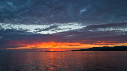 Fototapeta na wymiar Colorful sunset at sea, near west coast of Sithonia in Greece