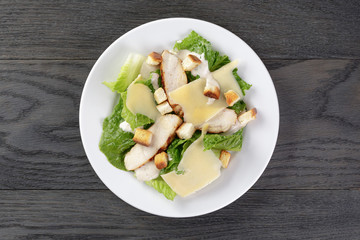 caesar salad with chicken on oak table