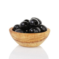 black olives in wooden bowl, isolated on white