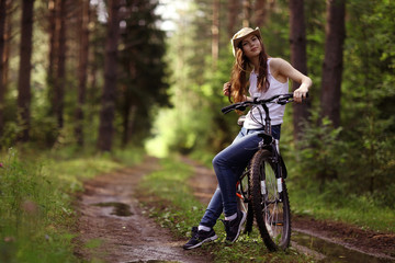 Fototapeta na wymiar young girl on a sports bike in a summer forest