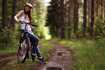 young girl on a sports bike in a summer forest