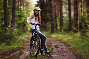 young girl on a sports bike in a summer forest