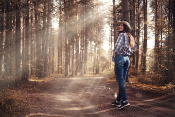 Fototapeta premium Beautiful girl in the forest landscape with sun rays