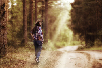 Fototapeta na wymiar Beautiful girl in the forest landscape with sun rays