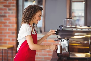 Smiling barista preparing a coffee