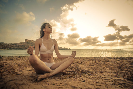 Young woman meditating at the beach
