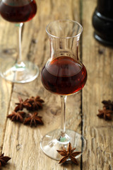 liquore distillato con anice stellata bicchiere su tavolo di legno sfondo rustico