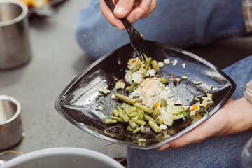 man eating meat with rice and vegetables in the forest in sunny