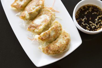 Jiaozi or gyoza, Chinese dumpling on black table with  sauce