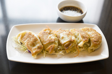 Jiaozi or gyoza, Chinese dumpling on black table with  sauce