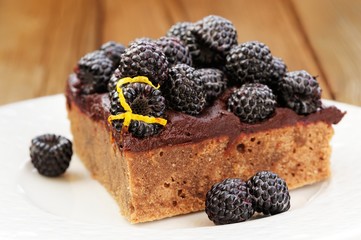 Piece of tasty chocolate pie with ganache, decorated with fresh