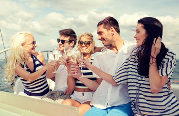 smiling friends with glasses of champagne on yacht