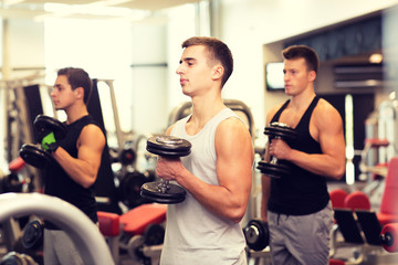 group of men with dumbbells in gym