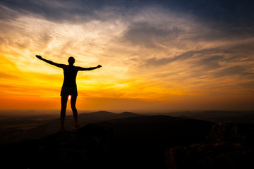 single adult woman silhouette on rock