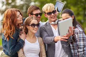 Fototapeta premium students or teenagers with tablet pc taking selfie