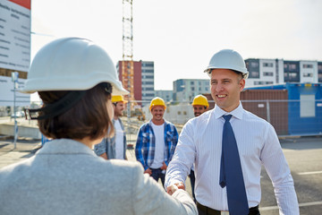 builders making handshake on construction site