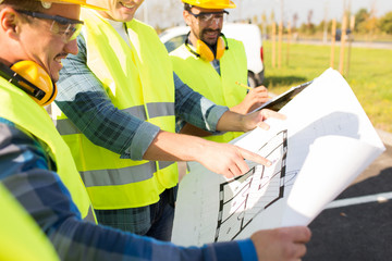 close up of builders with blueprint at building