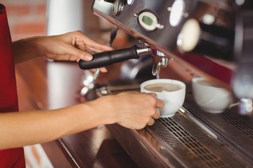 Fototapeta na wymiar A smiling barista preparing coffee