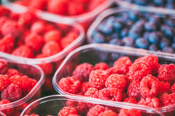 Baskets Full Of Raspberries And Blueberries On The Farmers Marke