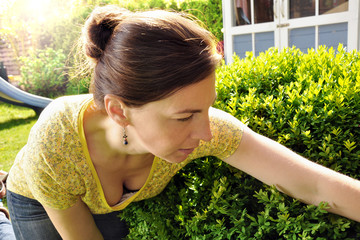 Frau im Garten bei Pflege von Pflanzen während Gartenarbeit