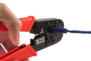 Isolated crimping pliers whith red handle, blue cord and hand on white background (hand is not focused)