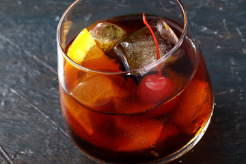 long drink con ghiaccio ciliegia e arancio bicchiere su sfondo scuro