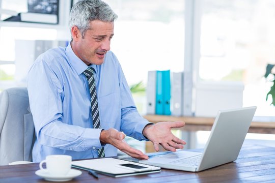 Confused Businessman Looking At Laptop Computer 