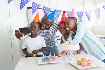 Happy family celebrating a birthday together and taking a selfie