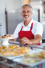 Barista smiling at camera behind counter