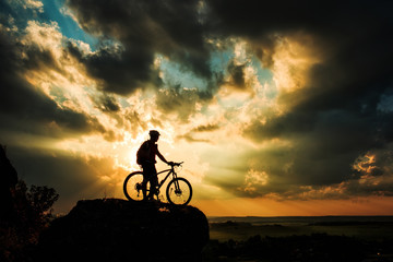 Obraz na płótnie Canvas Silhouette of a biker and bicycle on sky background.
