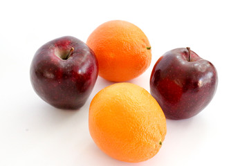 Two red apples and two oranges on white background