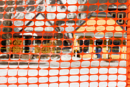 Orange Plastic Snow Fence In Front Of Homes