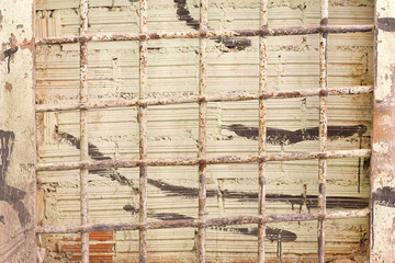 Bricked up window with an old and rusty bars.