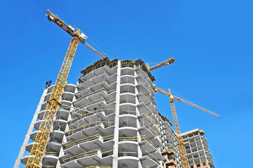  Crane and building construction site against blue sky