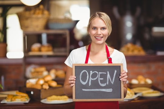 Pretty waitress with a chalkboard open sign