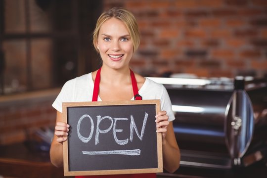 Pretty waitress with a chalkboard open sign